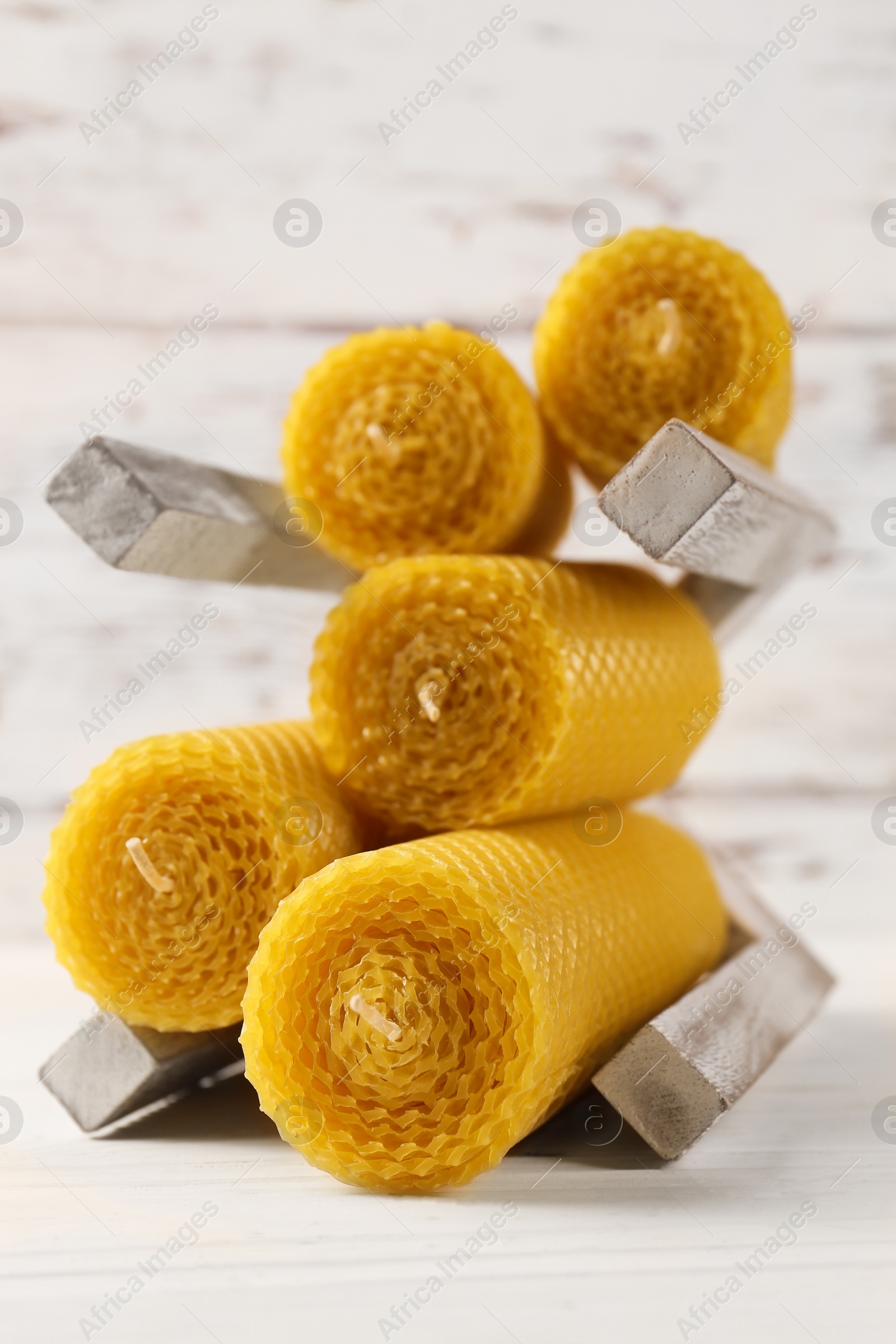 Photo of Stylish elegant beeswax candles on white wooden table