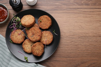 Delicious vegan cutlets served on wooden table, flat lay. Space for text