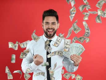 Image of Happy young man with money on red background