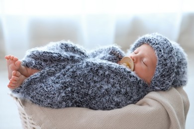 Cute newborn baby sleeping in basket at home