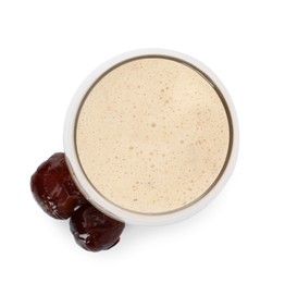 Glass of delicious date smoothie and dried fruits on white background, top view