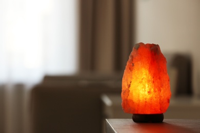 Photo of Himalayan salt lamp on table indoors, space for text