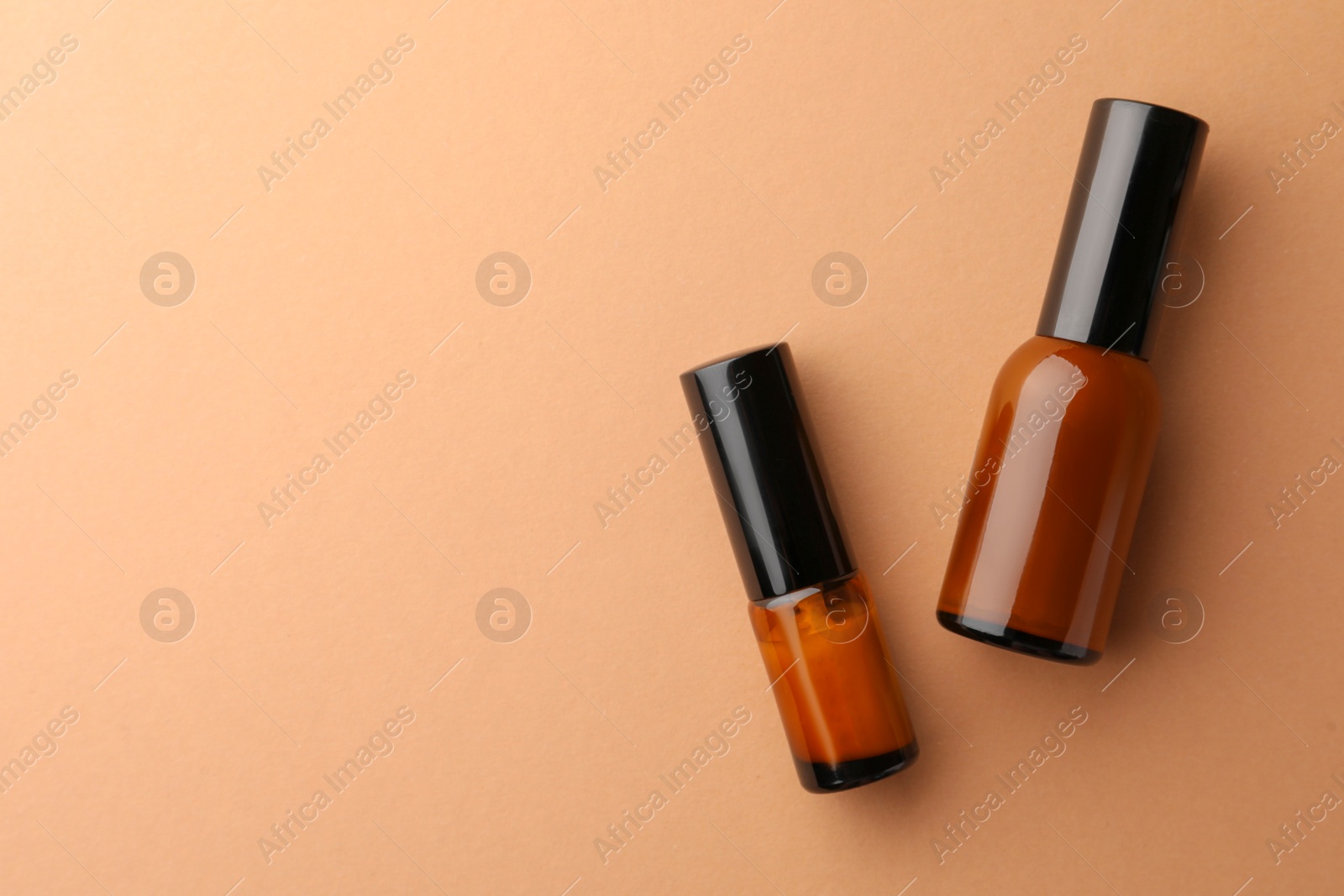 Photo of Bottles of face cream on beige background, flat lay. Space for text