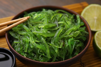 Photo of Tasty seaweed salad in bowl served on table, closeup