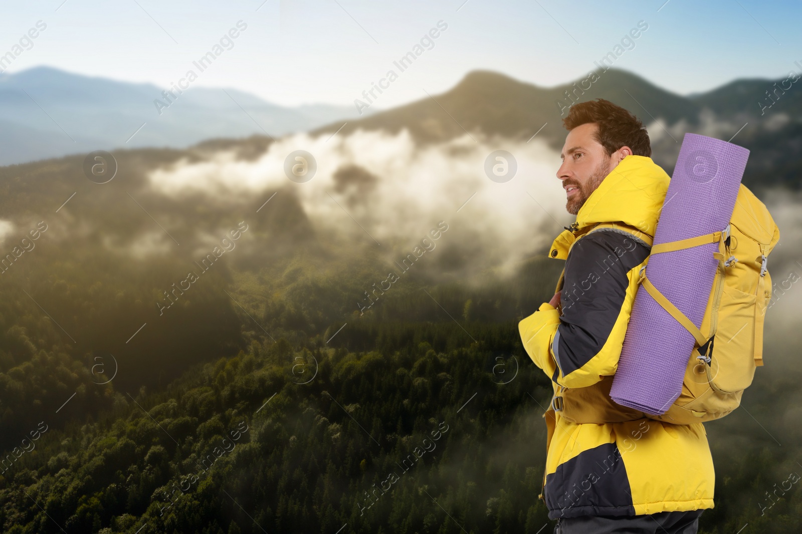 Image of Happy tourist with yellow backpack in mountains