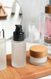 Different cosmetic products on white wooden table