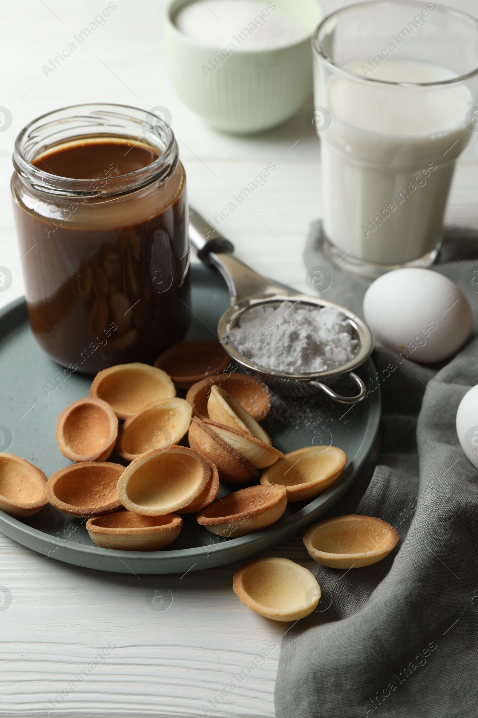 Photo of Ingredients for delicious walnut shaped cookies with condensed milk on white wooden table, closeup