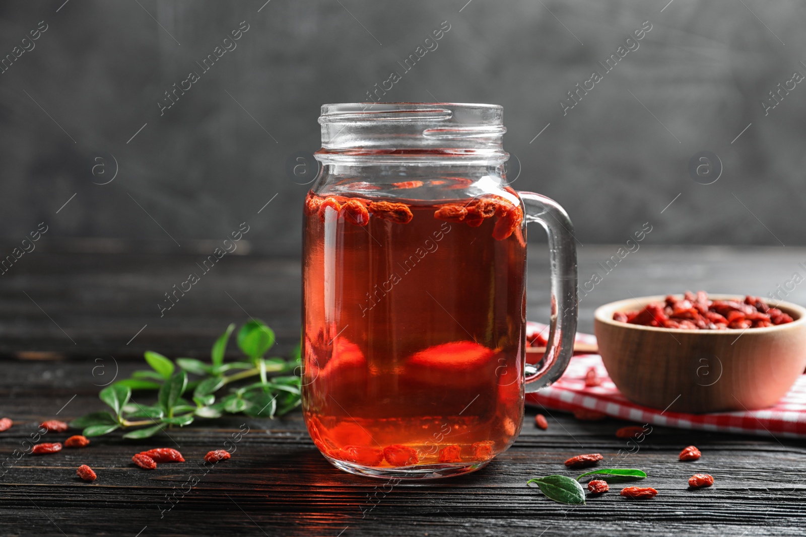 Photo of Healthy goji juice in mason jar on wooden table