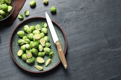 Photo of Plate with fresh Brussels sprouts on table, top view. Space for text