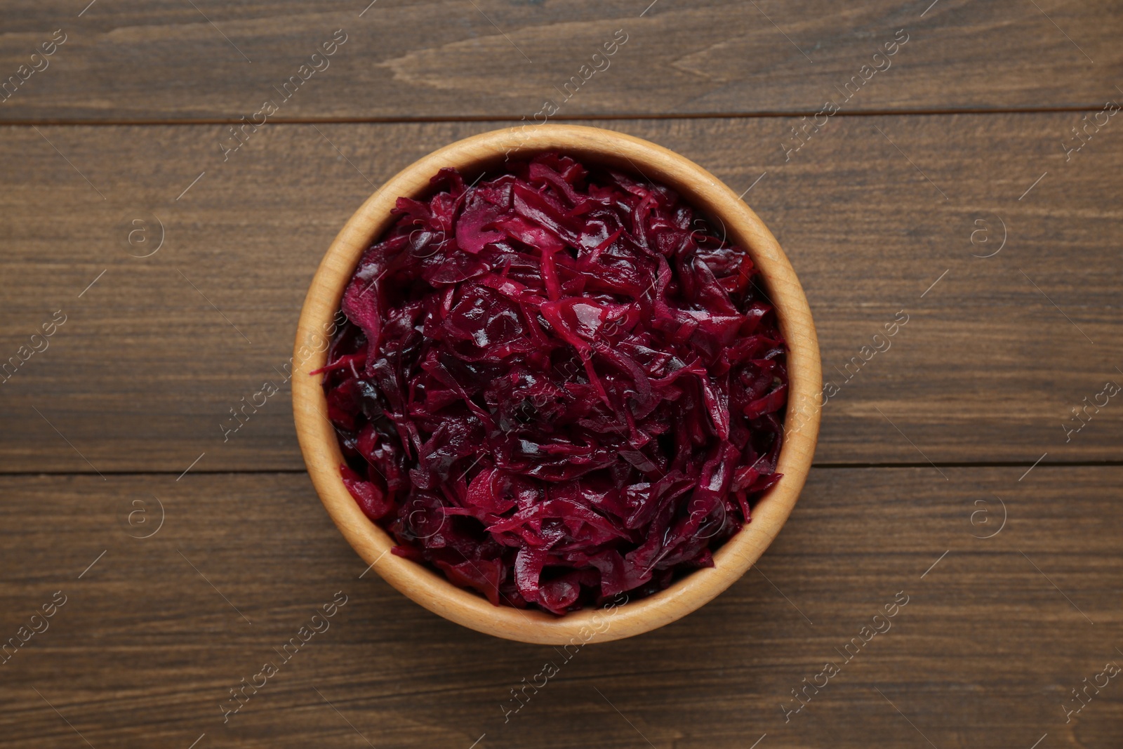 Photo of Tasty red cabbage sauerkraut on wooden table, top view