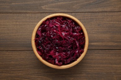 Photo of Tasty red cabbage sauerkraut on wooden table, top view