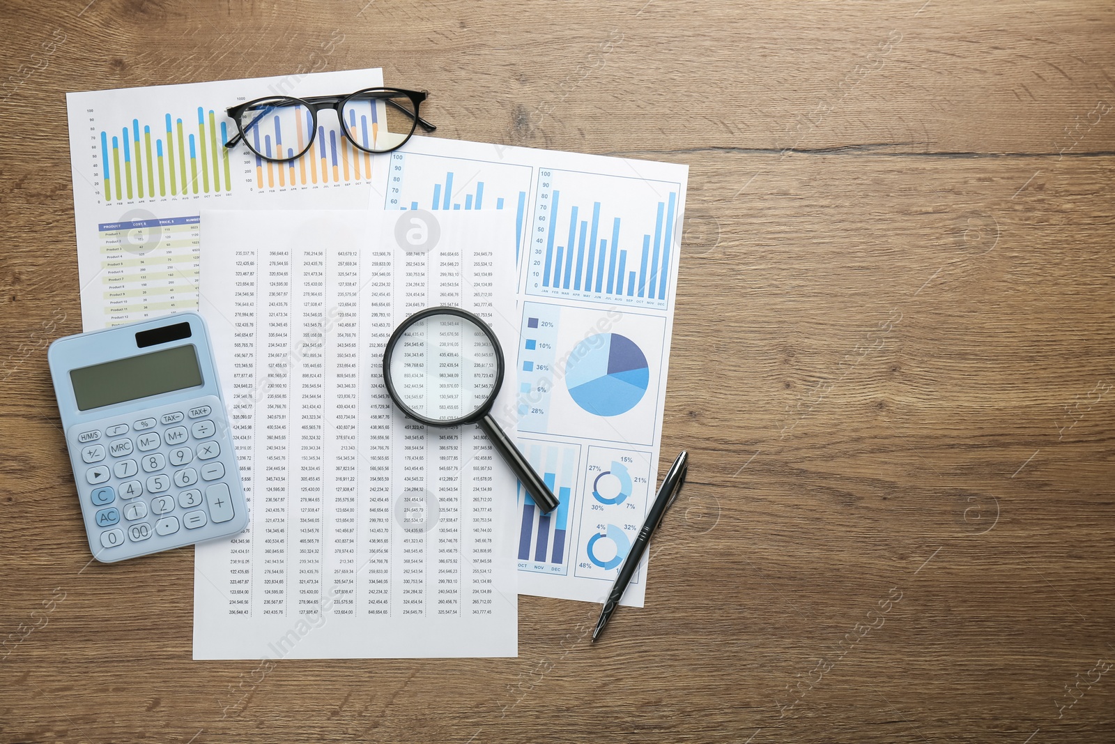 Photo of Accounting documents, magnifying glass, stationery and glasses on wooden table, top view. Space for text