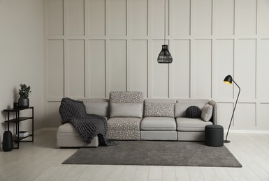 Living room interior with comfortable sofa near molding wall