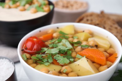Photo of Tasty chickpea soup in bowls on table, closeup