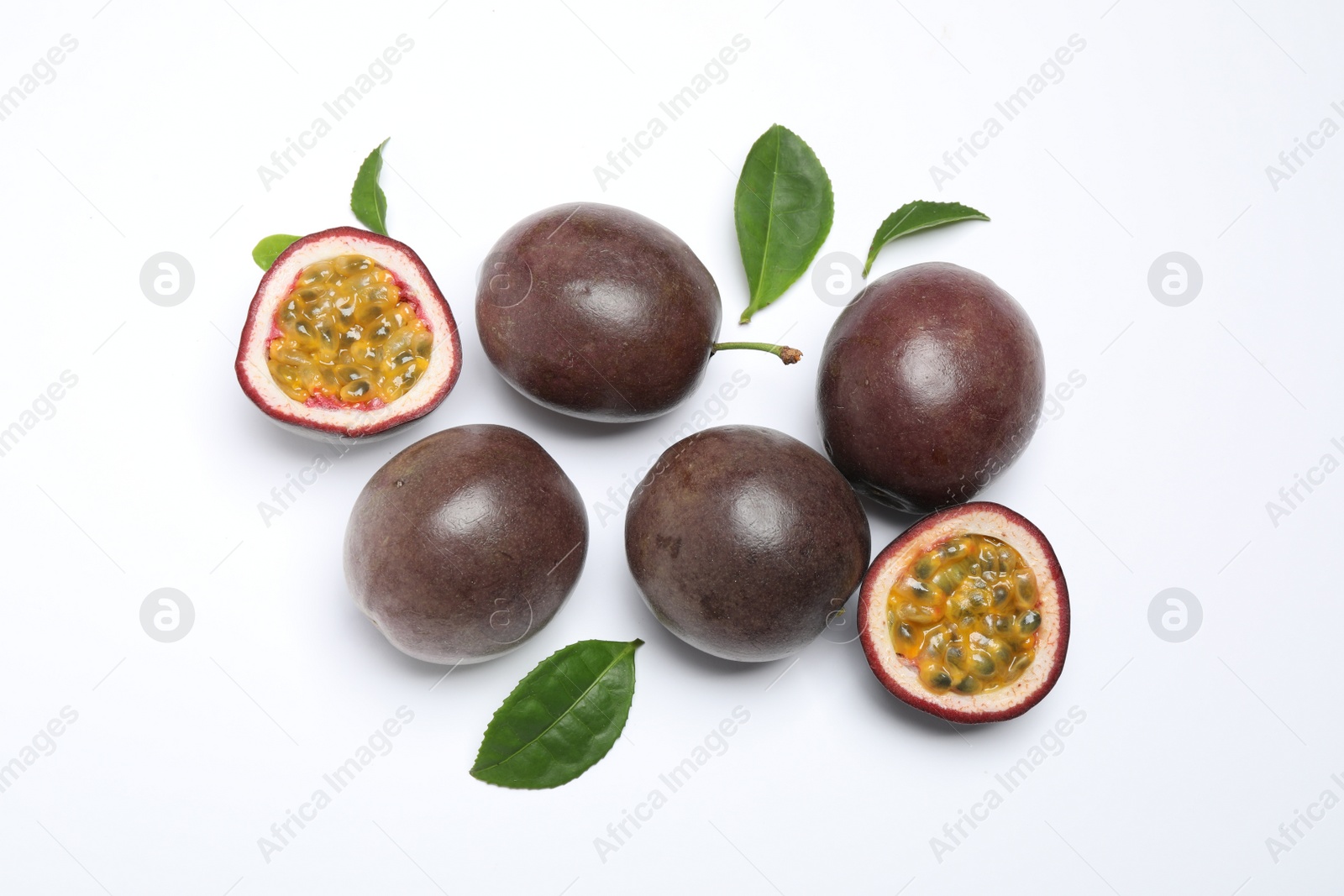 Photo of Fresh ripe passion fruits (maracuyas) with leaves on white background, flat lay