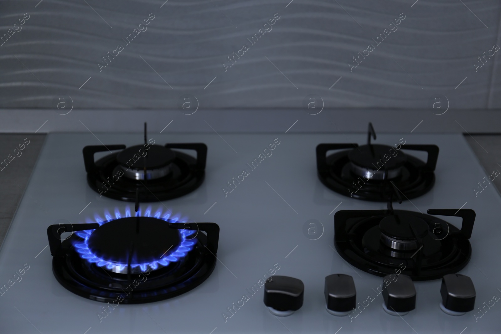 Photo of Modern kitchen stove with burning gas indoors