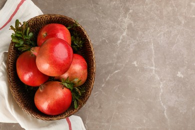 Photo of Delicious ripe pomegranates on grey table, flat lay. Space for text