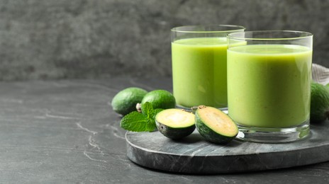 Fresh feijoa smoothie and fresh fruits on grey table, space for text. Banner design