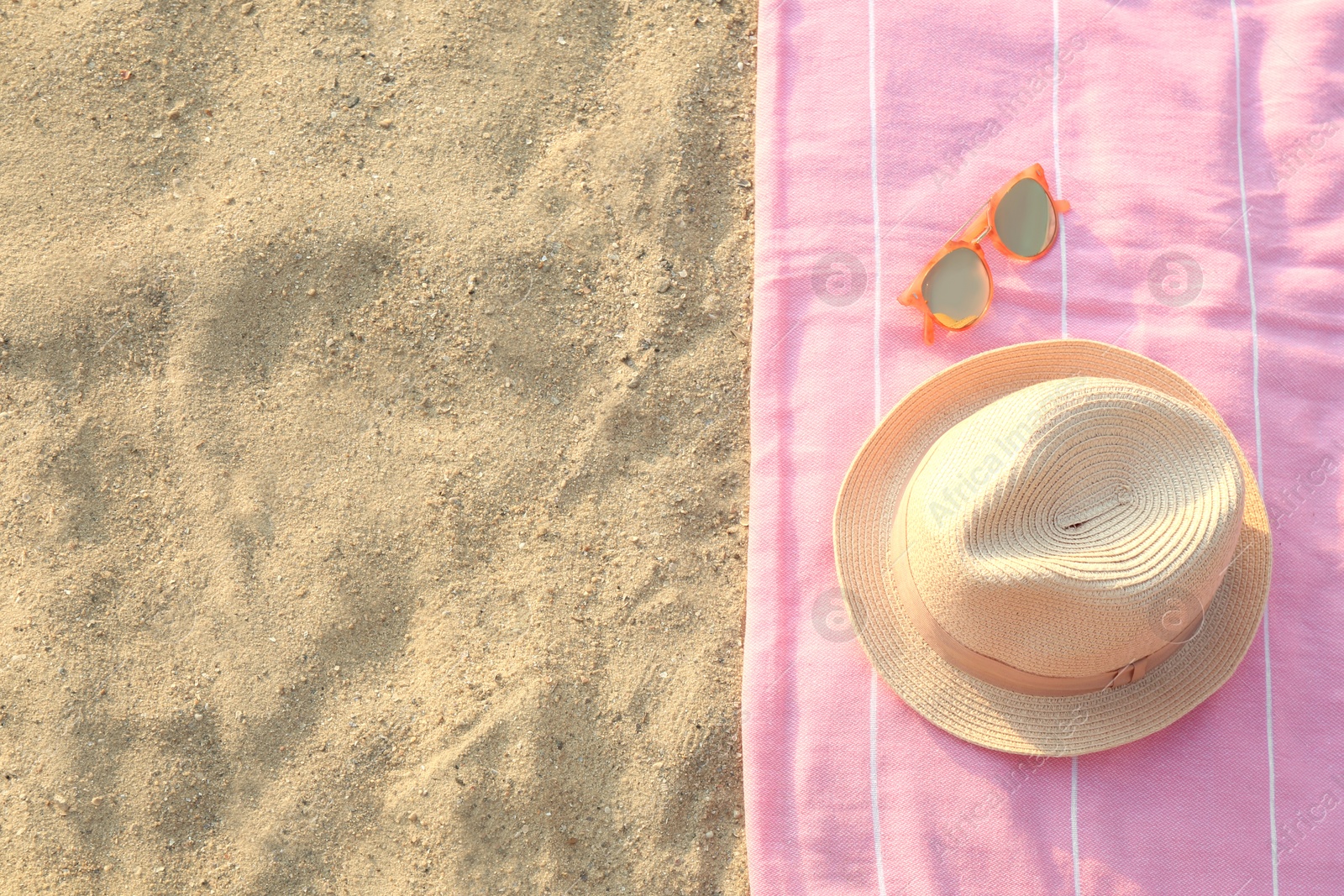 Photo of Beach accessories on sand, flat lay. Space for text