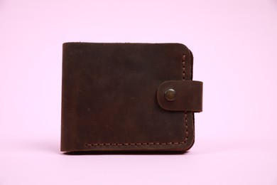 Stylish brown leather wallet on pink background