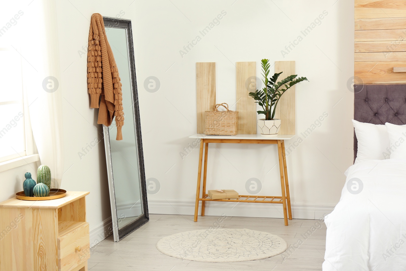 Photo of Stylish wooden table and mirror in modern bedroom interior