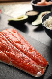 Photo of Fresh salmon for sushi on dark table, closeup