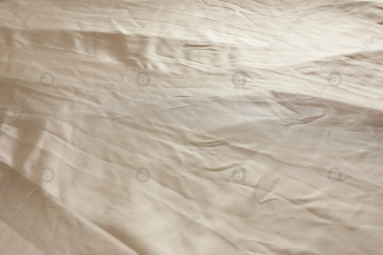 Photo of Crumpled dark beige fabric as background, closeup view