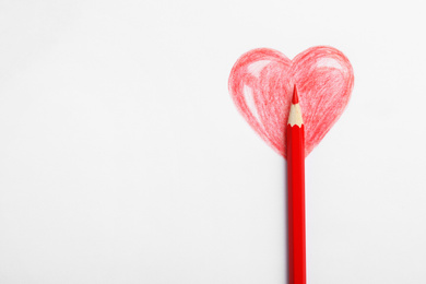 Drawing of heart and red pencil on white background, top view