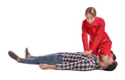 Photo of Paramedic in uniform performing first aid on unconscious man against white background
