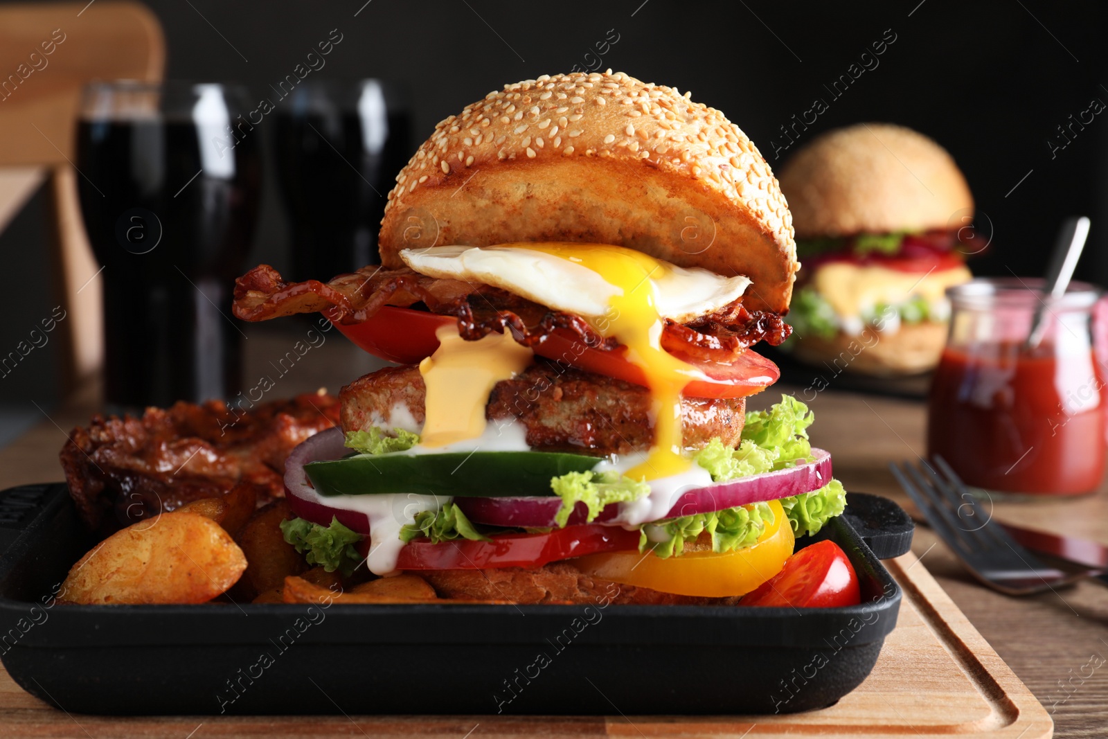 Photo of Serving pan with juicy bacon burger on wooden board