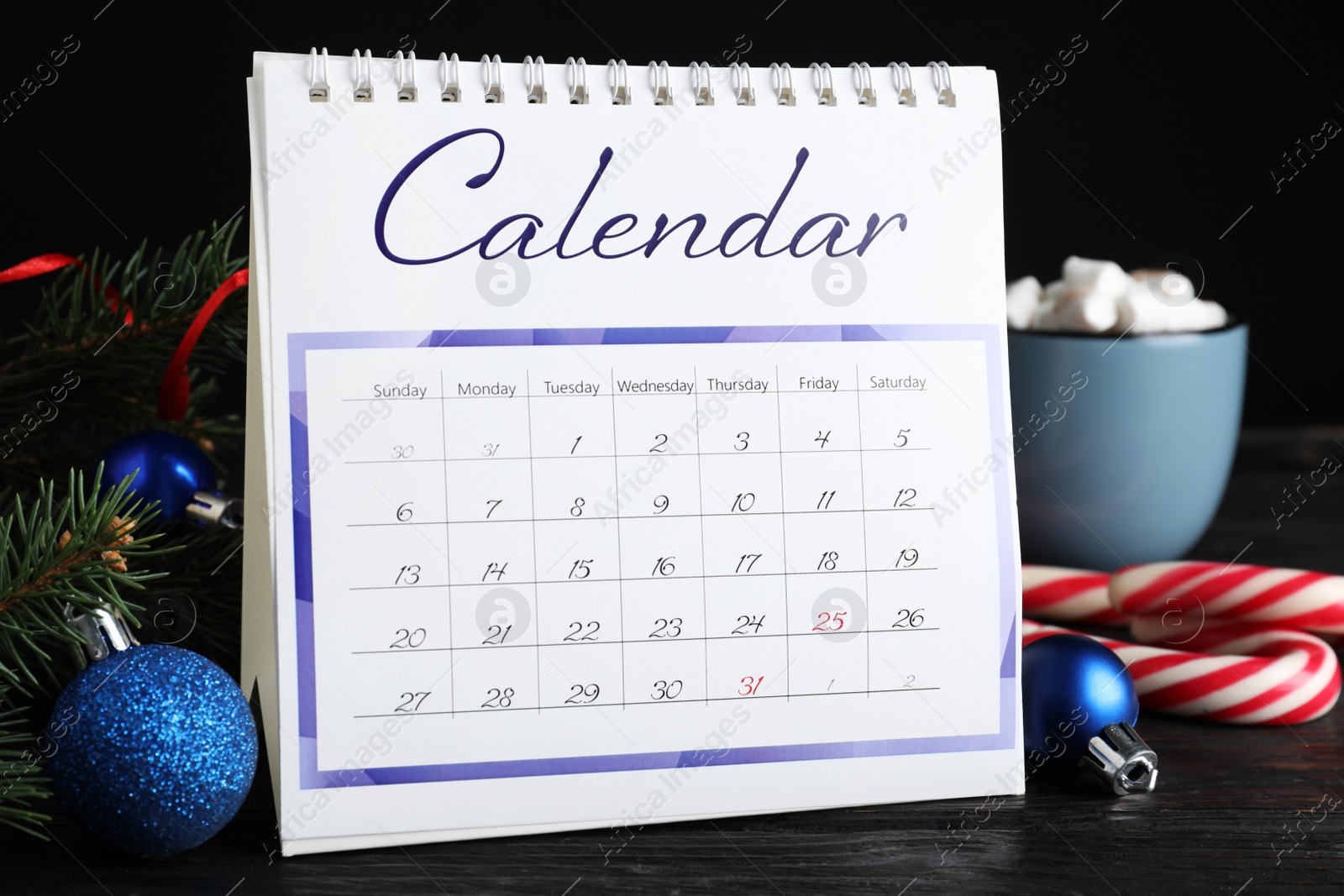 Photo of Flip calendar and Christmas decor on black wooden table. Holiday countdown