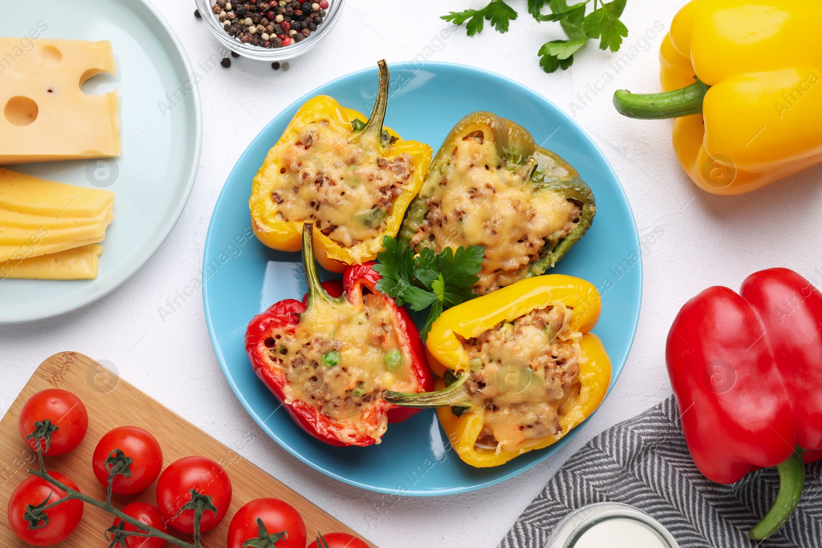 Photo of Flat lay composition with tasty stuffed bell peppers on white table