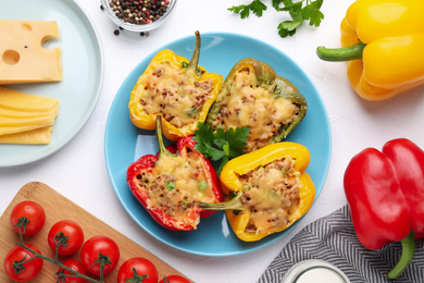 Photo of Flat lay composition with tasty stuffed bell peppers on white table