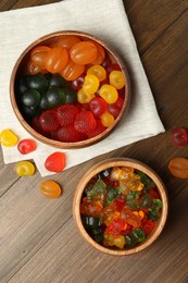 Photo of Delicious gummy candies on wooden table, flat lay