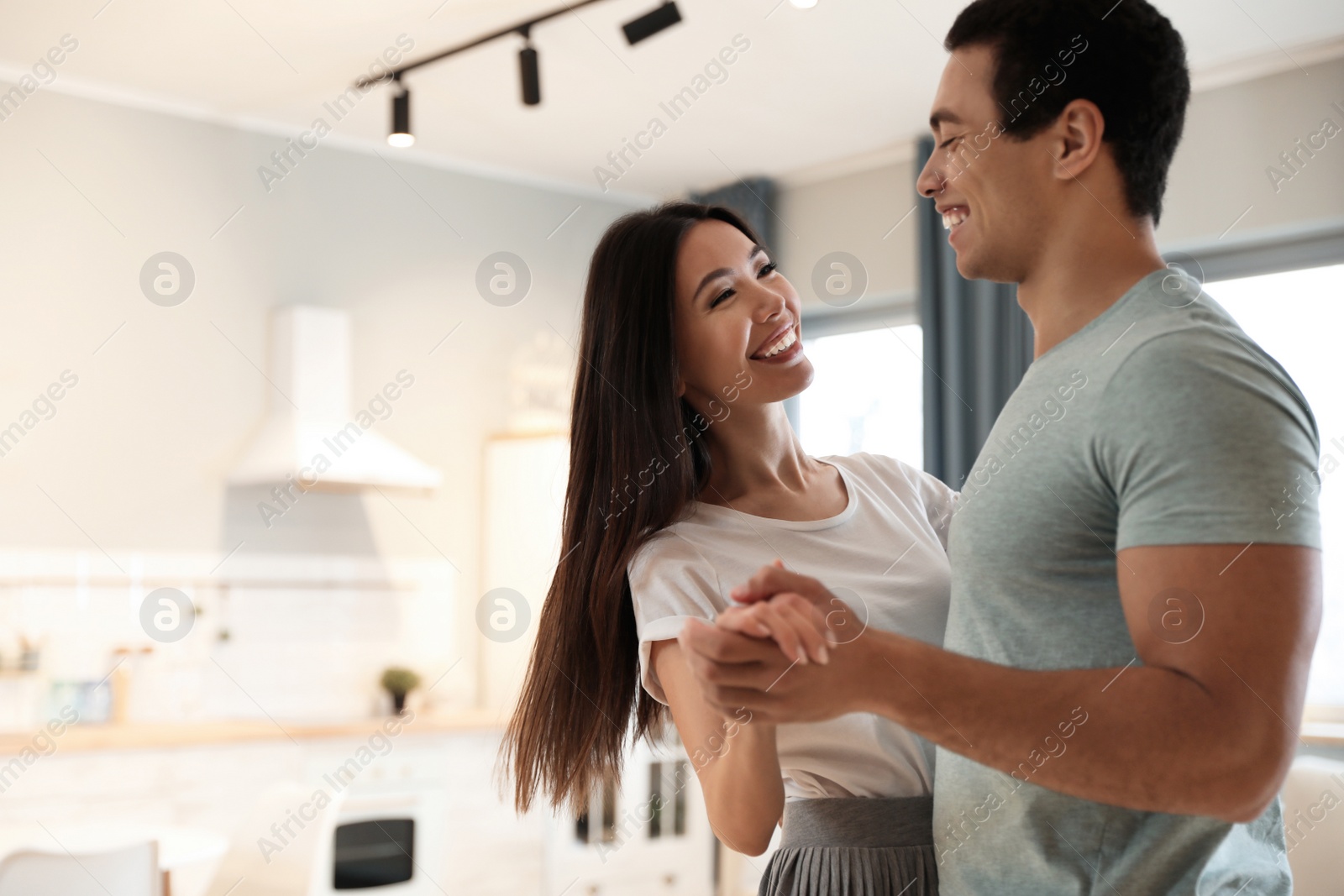 Photo of Lovely young interracial couple dancing at home