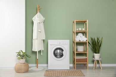 Photo of Stylish laundry room with washing machine. Interior design