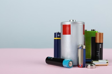 Image of Different types of batteries on color background, space for text
