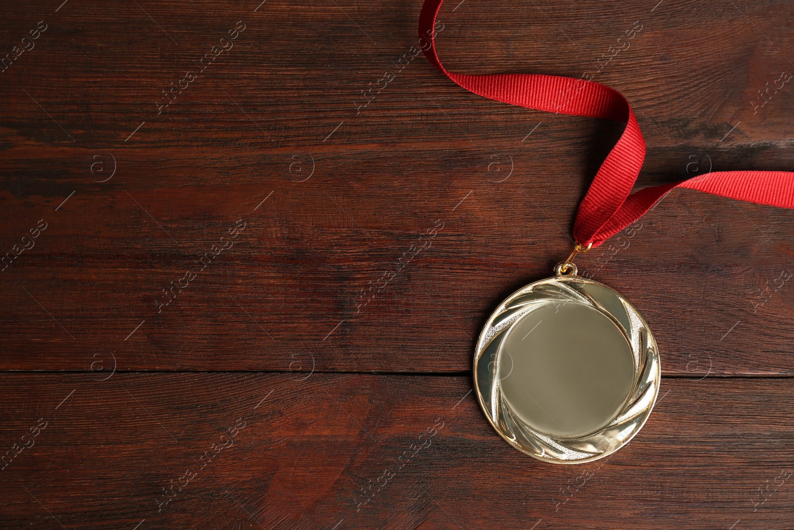 Photo of Gold medal on wooden background, top view. Space for design