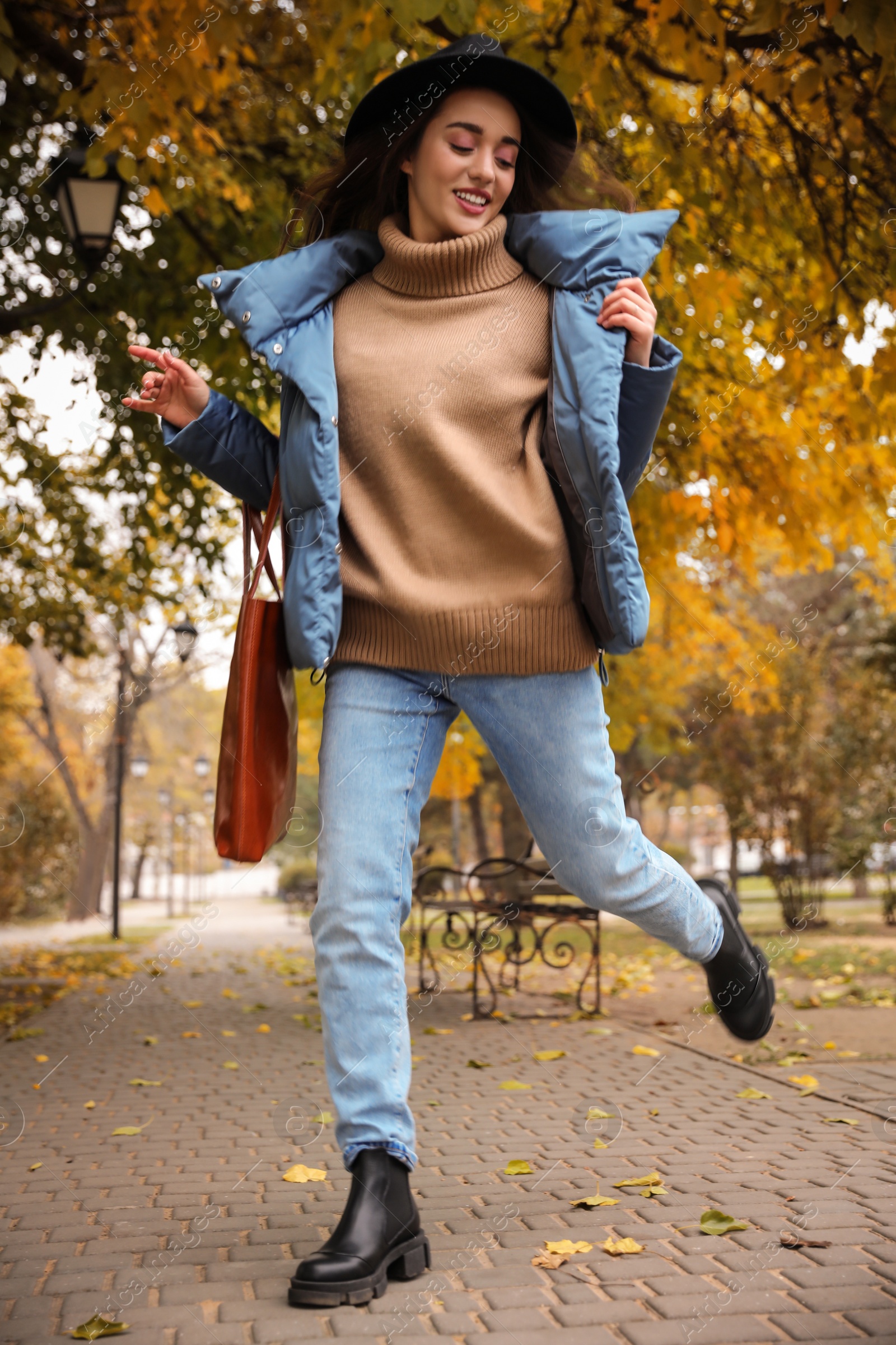 Photo of Young woman wearing stylish clothes in autumn park