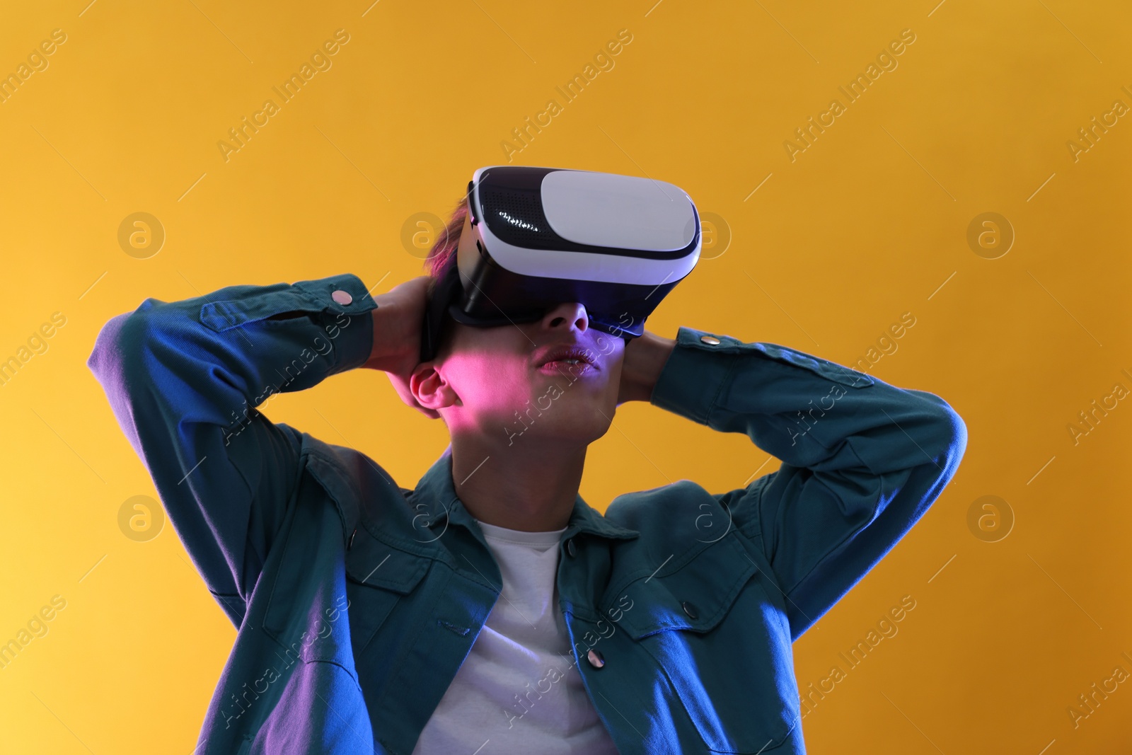 Photo of Young man with virtual reality headset on yellow background