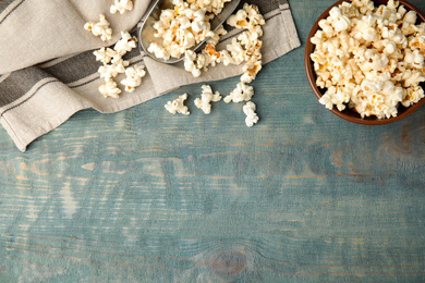 Flat lay composition with tasty pop corn on blue wooden table, space for text