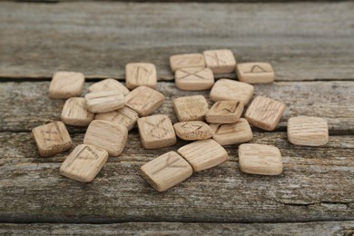 Pile of runes with different symbols on wooden table