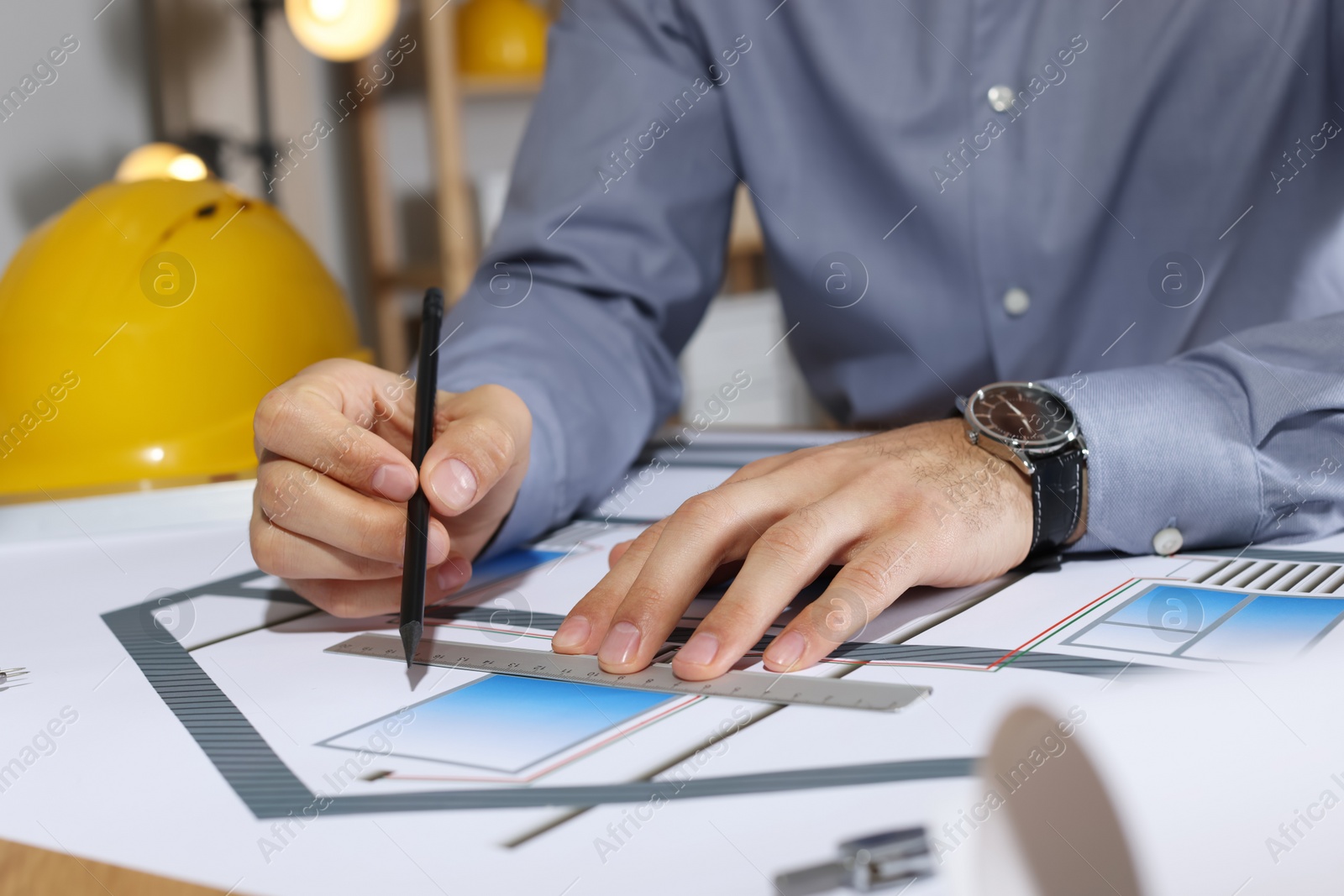 Photo of Architect working with construction drawings in office, closeup