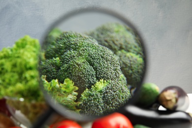 Photo of View through magnifying glass on broccoli, closeup. Poison detection