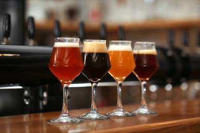 Photo of Different beers in glasses on bar counter