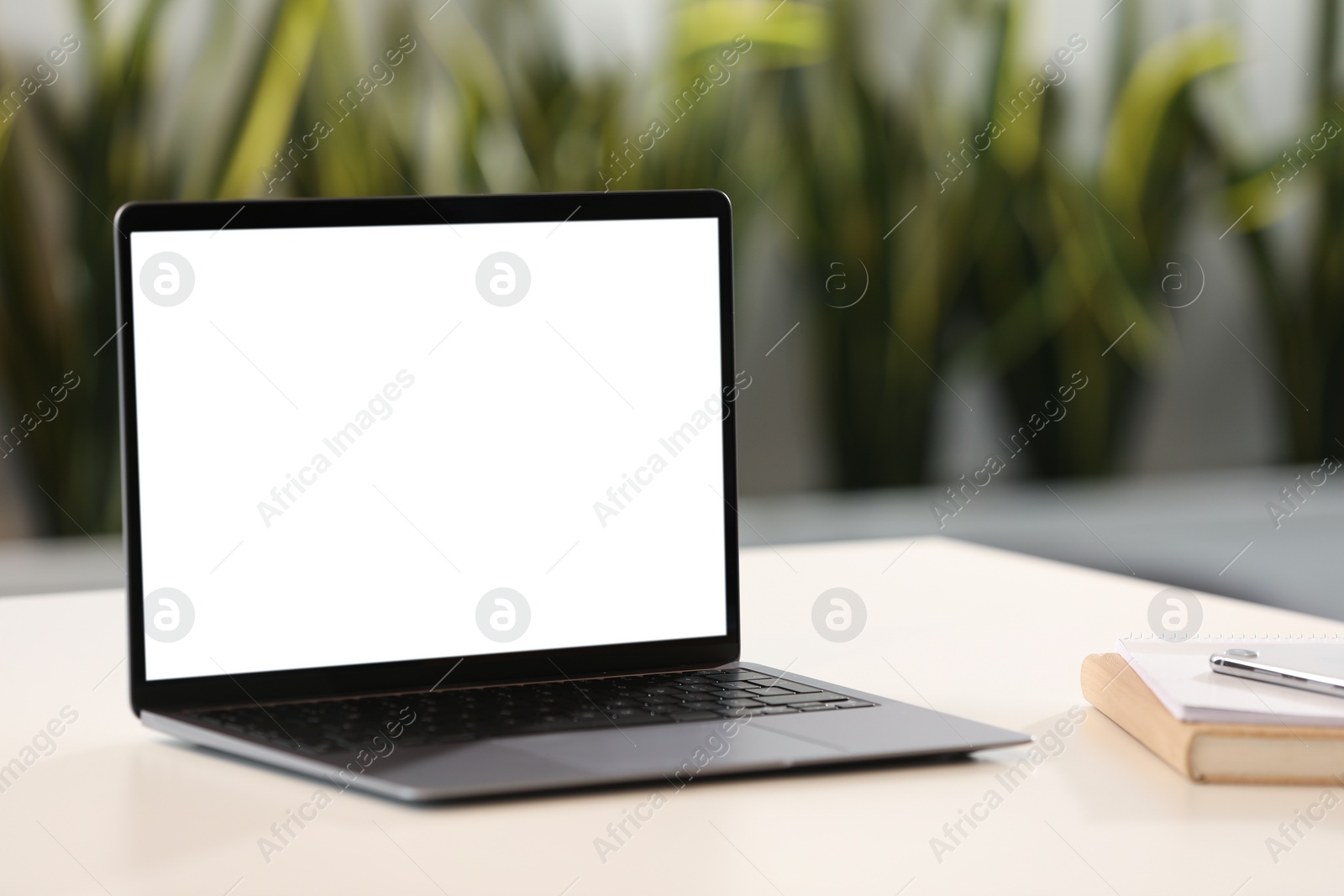 Photo of Modern laptop on desk in office. Mockup for design
