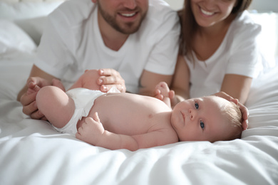 Photo of Happy couple with their newborn baby on bed, closeup