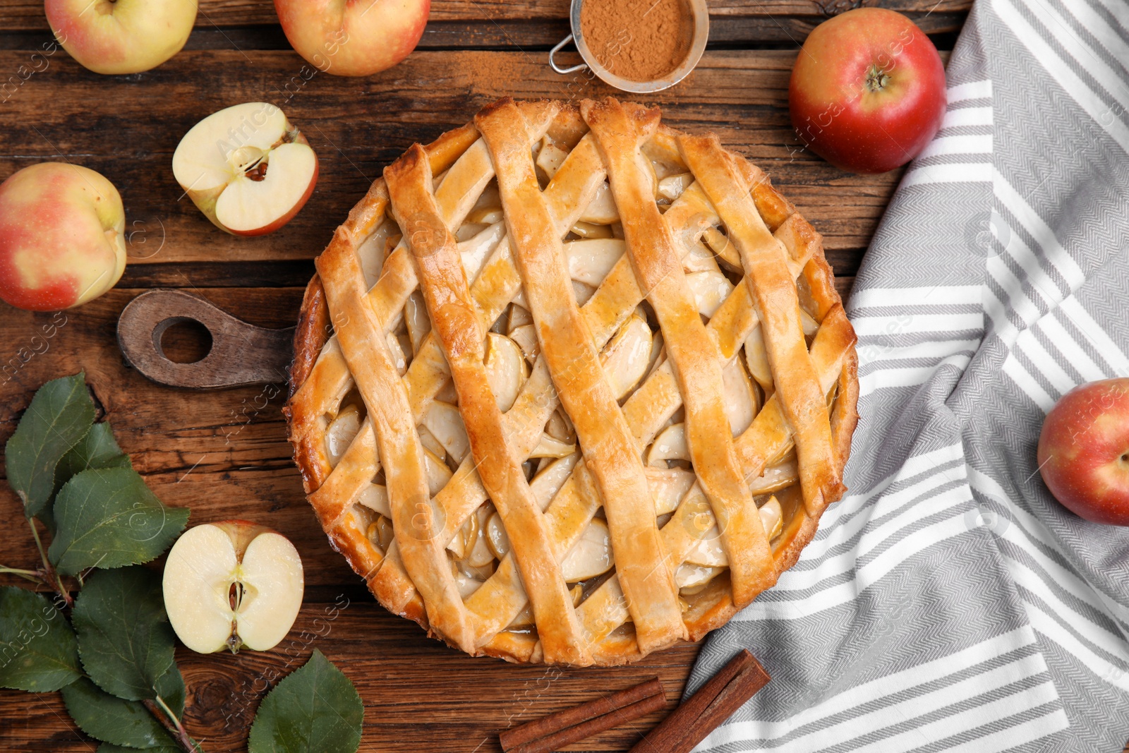 Photo of Delicious traditional apple pie on wooden table, flat lay