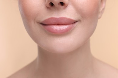 Photo of Woman with beautiful lips on beige background, closeup