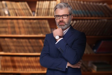 Image of Confident lawyer against shelves with books, space for text
